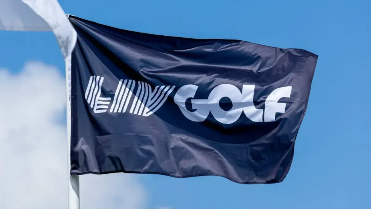 Bandera azul marino con el logotipo blanco de LIV Golf ondeando al viento contra un cielo azul