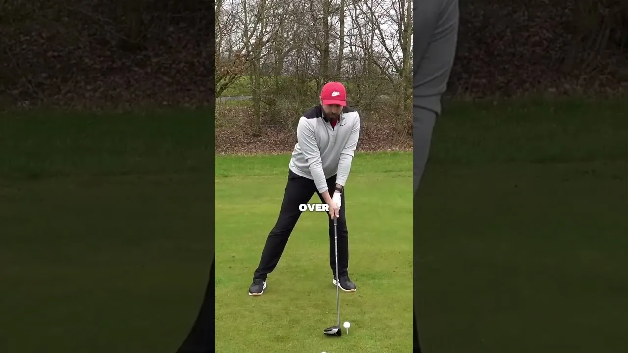Rick Shiels prepara un golpe con el driver en un campo de golf, con gorra roja y jersey gris