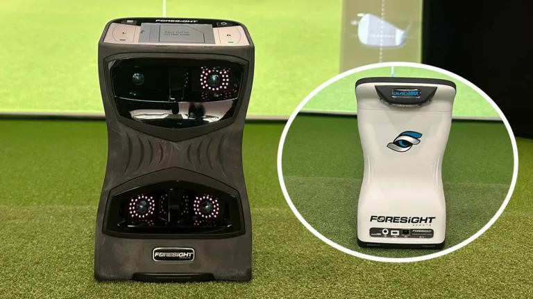 Dos monitores Foresight QuadMax sobre césped sintético en un simulador de golf: uno negro y otro blanco