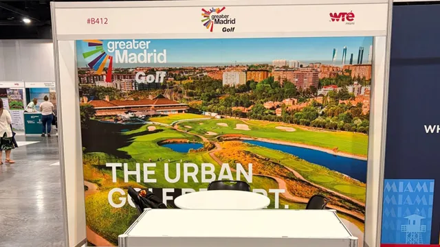 Stand de Greater Madrid Golf en una feria: panel de campo de golf urbano con skyline y mostrador blanco delante