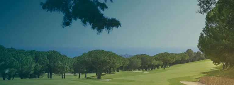 Vista de un campo de golf de montaña con el Mediterráneo al fondo en la Costa Brava