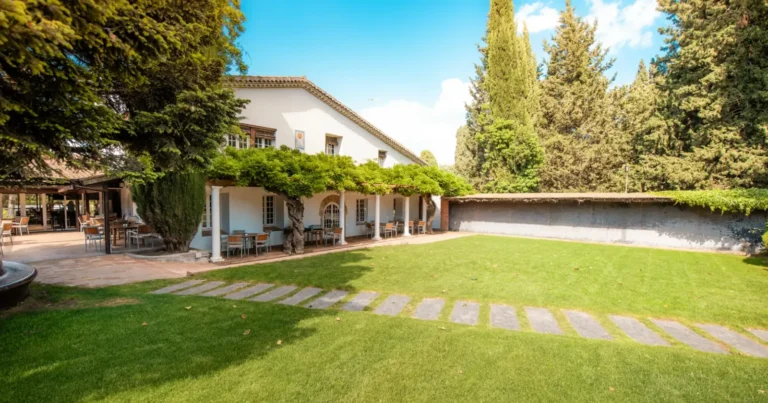 Calle de un campo de golf entre pinos y árboles centenarios en un entorno boscoso